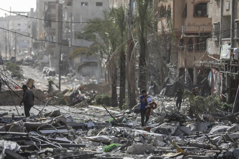 Palestinians walk through Gaza City on Sunday, Nov. 26, 2023. on the third day of the temporary ceasefire between Hamas and Israel. (AP Photo/Mohammed Hajjar)