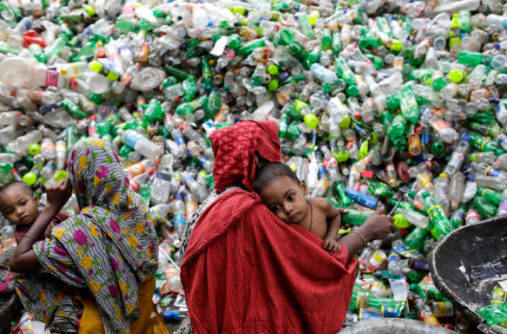 In Bangladesch in Indien sortieren weibliche Tagelöhner unzählige PET-Flaschen, während sie ihre Kinder auf dem Arm tragen. Das Recyceln der Plastikflaschen ist in den letzten Jahren zu einem lukrativen Geschäft in Bangladesch geworden. (Foto: Abir Abdullah/EPA)