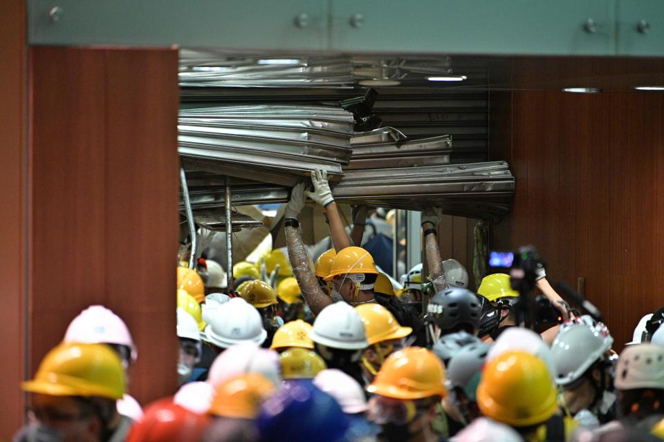 Protesters break into the government headquarters in Hong Kong on July 1, 2019, on the 22nd anniversary of the city's handover from Britain to China. - Anti-government protesters stormed Hong Kong's parliament building late on July 1 after successfully smashing their way through reinforced glass windows and prizing open metal shutters that were blocking their way. (Photo by Anthony WALLACE / AFP)        (Photo credit should read ANTHONY WALLACE/AFP/Getty Images)