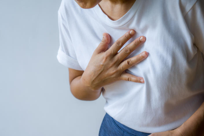Woman hand  holding chest with symptom heart attack disease.