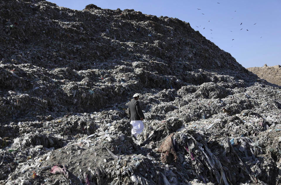 In this Oct. 23, 2019 photo, Abdul Basir Akhundzada head of Kabul municipality garbage dump yard, walks at garbage dump yard on the outskirts of Kabul, Afghanistan. Kabul, a city of some 6 million, has become one of the most polluted cities in the world, as decades of war have wrecked infrastructure and caused waves of displaced people. Authorities are trying to tackle pollution in the country’s capital, which may be even deadlier than 18-year-old war. (AP Photo/Rahmat Gul)