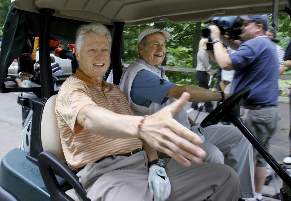 FILE - Former President Bill Clinton, left, reaches to shake a hand of a wellwisher as he and former President George H.W. Bush head off to start a round of golf at the Cape Arundel Golf Club in Kennebunkport, Maine, Tuesday, June 28, 2005. The history of golf courses serving as a boardroom with grass is a lengthy one. Corporate executives and politicians have used the game as a chance to make deals and generate influence for years. (AP Photo/Pat Wellenbach, File)