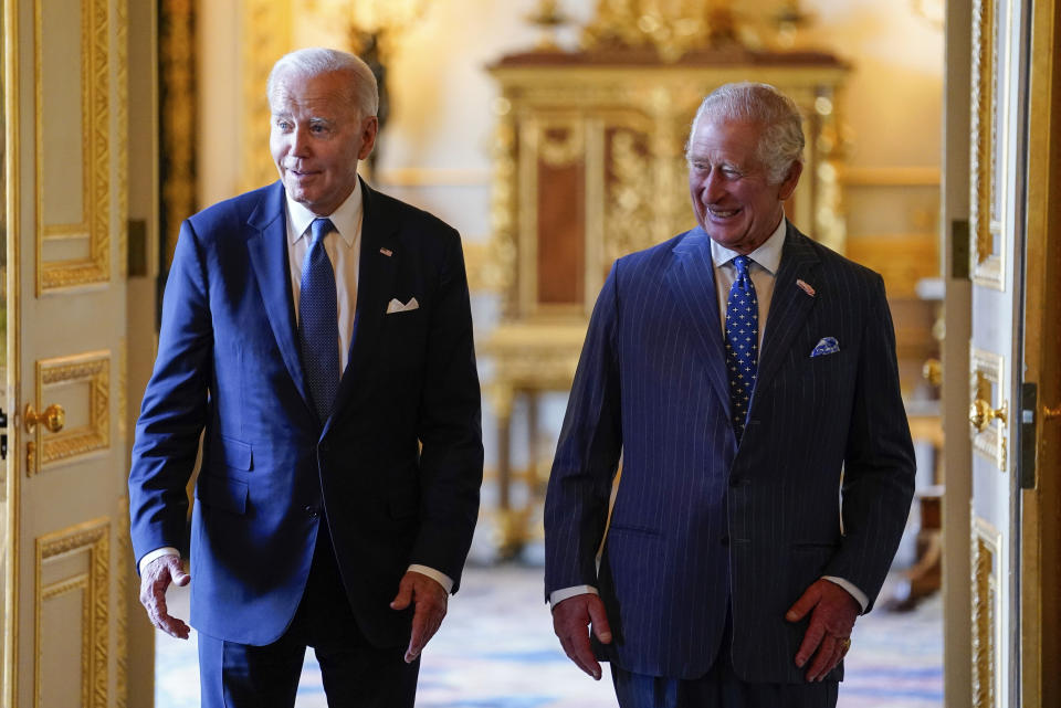 FILE - Britain's King Charles III, right, and US President Joe Biden arrive to meet participants of the Climate Finance Mobilisation forum in the Green Drawing Room at Windsor Castle, England, Monday July 10, 2023. King Charles III has been diagnosed with a form of cancer and has begun treatment, Buckingham Palace said Monday Feb. 5, 2024. Less than 18 months into his reign, the 75-year-old monarch will suspend public duties but will continue with state business, and won't be handing over his constitutional roles as head of state. (Andrew Matthews/Pool via AP, File)