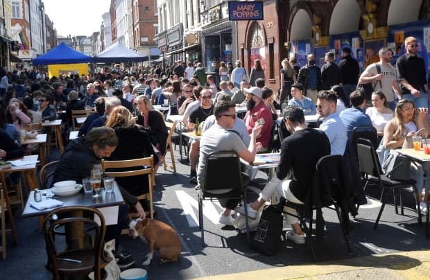 People eat and drink outside in the Soho section of London on April 24, 2021.  (Toby Melville/Reuters - image credit)