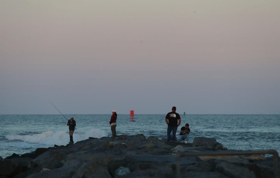People fish off the jetty marking the Indian River Inlet at sunset, Saturday, Sept. 2, 2023 during the unofficial end to summer, Labor Day Weekend.