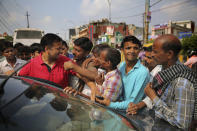 In this Sunday, Sept. 8, 2019, photo, Indian daily wage laborers and construction workers jostle as a man, in red shirt, tries to hire them, on the outskirts of New Delhi, India. Confidence in the Indian economy is giving way to uncertainty as growth in the labor-intensive manufacturing sector has come to a near standstill, braking to 0.6% in the last quarter from 12.1% in the same period a year earlier. (AP Photo/Altaf Qadri)