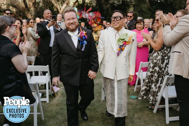 <p>Logan Cole Photography</p> Zeke Smith (left) and Nico Santos are cheered by their guests after tying the knot.