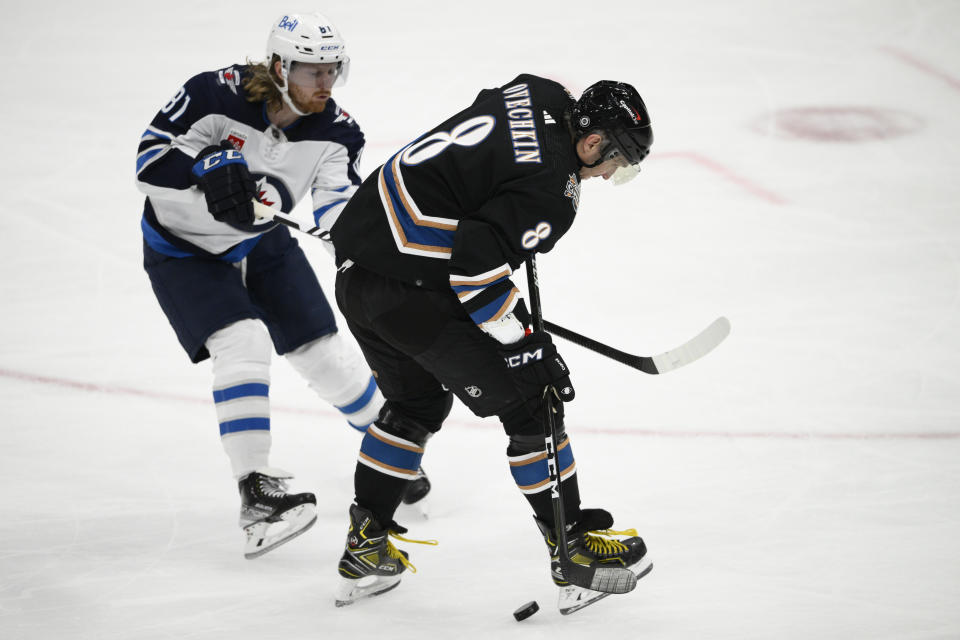 Washington Capitals left wing Alex Ovechkin (8) battles for the puck against Winnipeg Jets left wing Kyle Connor (81) during the first period of an NHL hockey game, Friday, Dec. 23, 2022, in Washington. (AP Photo/Nick Wass)