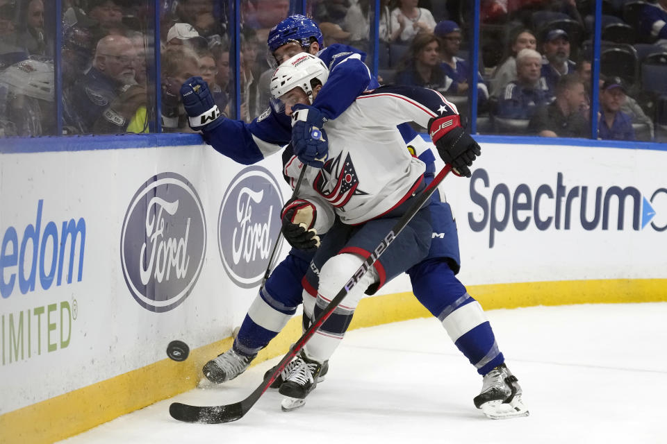 Tampa Bay Lightning defenseman Nick Perbix, rear, gets Columbus Blue Jackets right wing Justin Danforth (17) in a headlock as they play the puck during the first period of an NHL hockey game Tuesday, April 9, 2024, in Tampa, Fla. (AP Photo/Chris O'Meara)