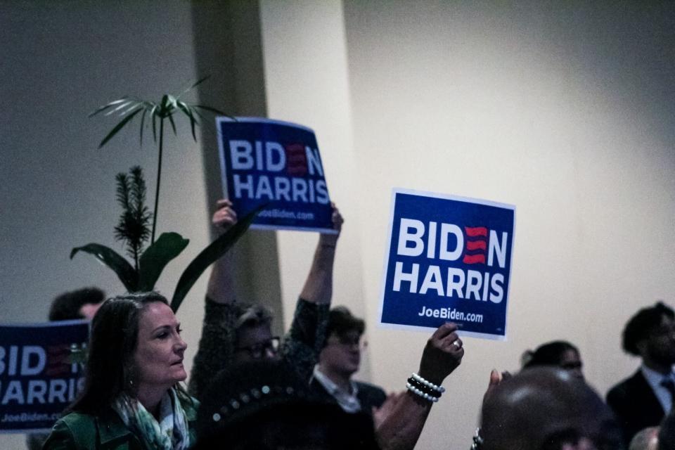 Attendees at the First-in-the-Nation dinner in Columbia, S.C. hold up signs reading "Biden Harris" on Jan. 27, 2024.