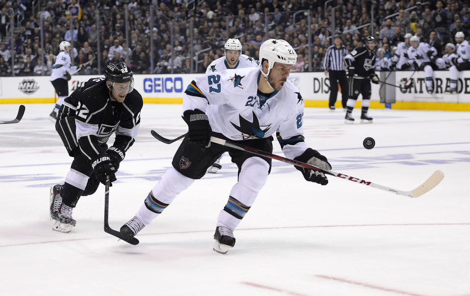 Los Angeles Kings center Trevor Lewis, left, and San Jose Sharks defenseman Scott Hannan vie for the puck during the second period in Game 6 of an NHL hockey first-round playoff series, Monday, April 28, 2014, in Los Angeles. (AP Photo)