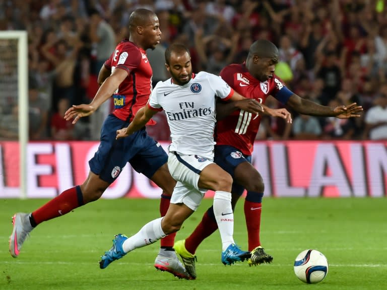 Paris Saint-Germain's midfielder Lucas (C) clashes with Lille's midfielder Rio Mavuba (R) during their French L1 football match on August 7, 2015 in Villeneuve d'Ascq, France