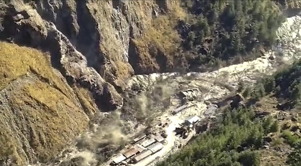 En esta escena tomada de un video proporcionado por KK Productions, una gran masa de agua, lodo y escombros fluye por el distrito Chamoli tras el desprendimiento de parte del glaciar de Nanda Devi en la zona de Tapovan, en el estado norteño de Uttarakhand, India, el domingo 7 de febrero de 2021. (KK Productions via AP)