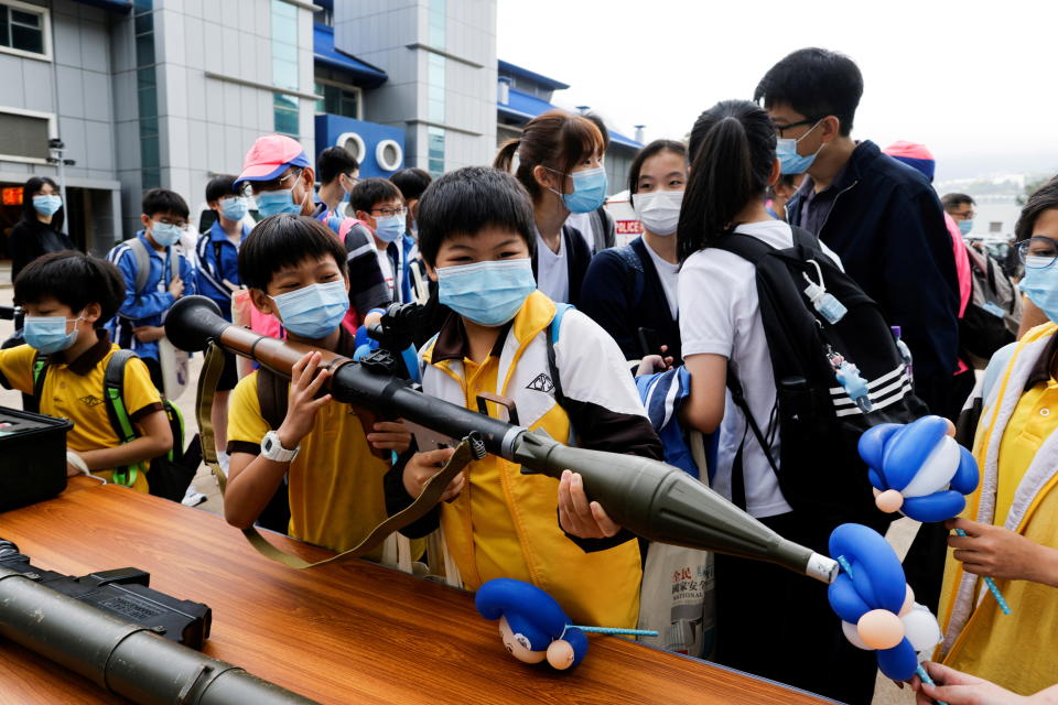 香港全民國家安全教育日當天，學生輪流試用模擬榴彈發射器。圖片來源：Reuters。