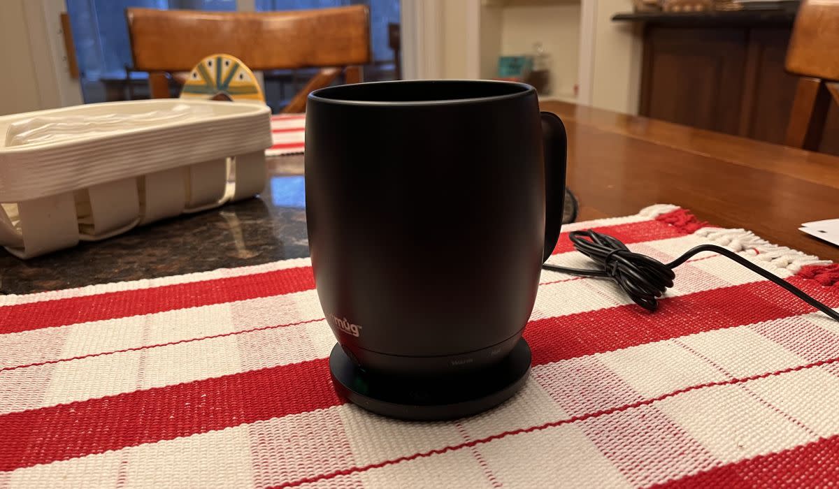 The Nextmug shown sitting on its charging dock, which resembles a coaster.