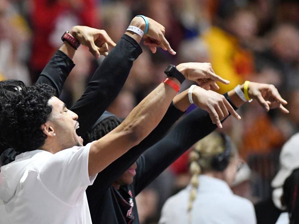 Texas Tech track and field athletes gesture Horns down after the Red Raiders' Courtney Lindsey won the 200 meters in a personal record 20.13 seconds Saturday at the Big 12 indoor championships.