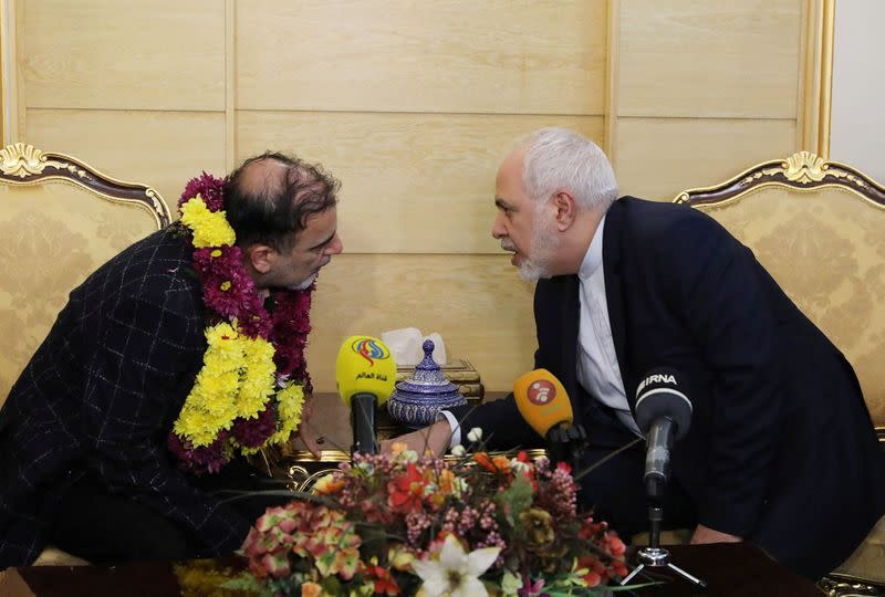 Iranian professor Massoud Soleimani speaks with Iran's Foreign Minister Mohammad Javad Zarif during his arrival at Mehrabad airport, in Tehran