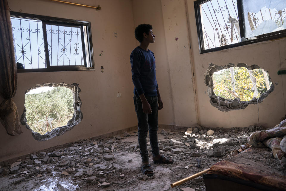 Issat Al-Masri, 18, stands for a portrait in his bedroom that was damaged by shelling prior to a cease-fire that halted an 11-day war between Gaza's Hamas rulers and Israel, Wednesday, May 26, 2021, in Beit Hanoun, Gaza Strip. (AP Photo/John Minchillo)