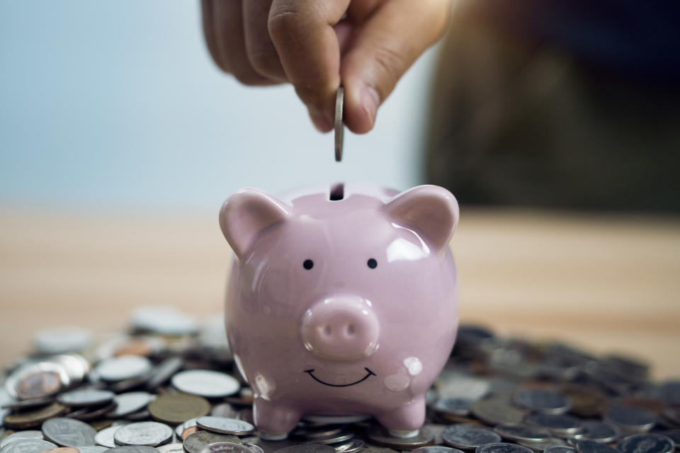 Person putting change in a piggy bank