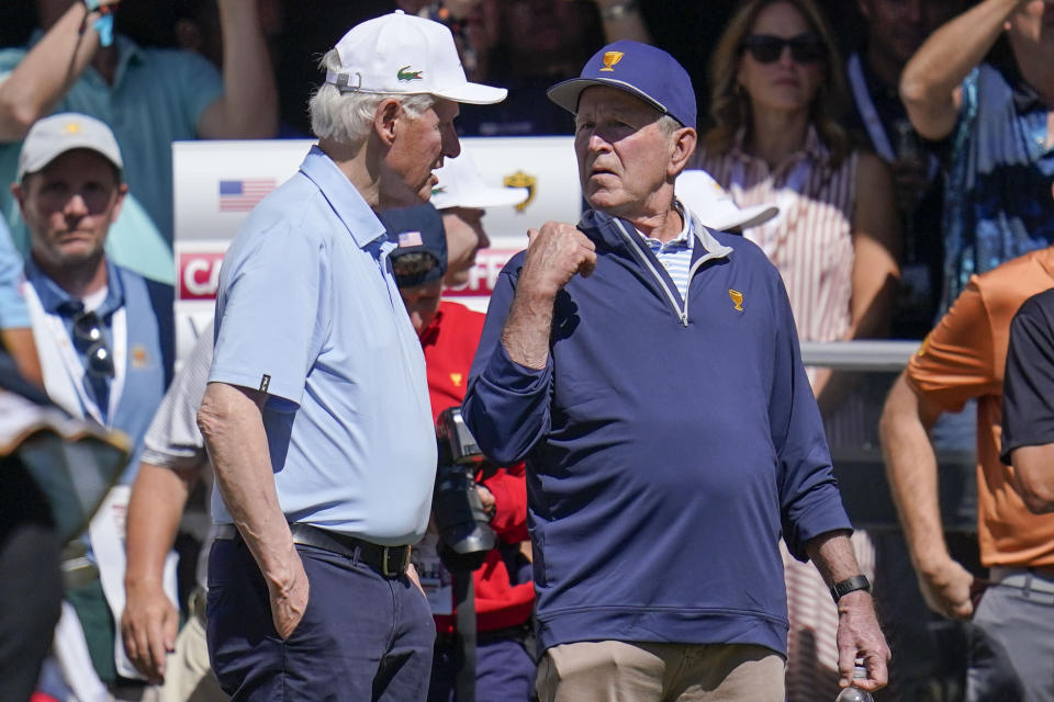 Former President's Bill Clinton, left and George W. Bush speak on the first tee during a fourball match at the Presidents Cup golf tournament at the Quail Hollow Club, Friday, Sept. 23, 2022, in Charlotte, N.C. (AP Photo/Julio Cortez)