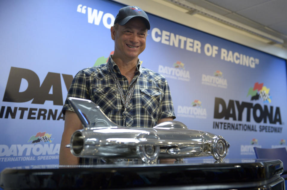 Actor Gary Sinise poses with the winner's trophy for the NASCAR Daytona 500 Sprint Cup series auto race at Daytona International Speedway during a news conference in Daytona Beach, Fla., Sunday, Feb. 23, 2014. (AP Photo/Phelan M. Ebenhack)