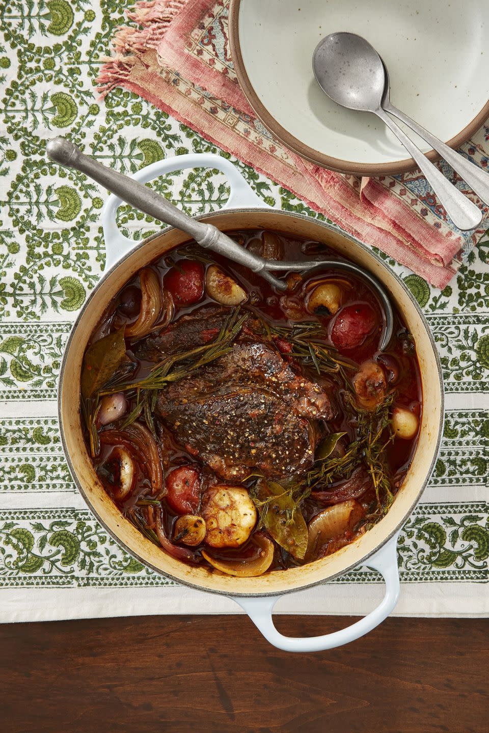 braised beef with tomatoes and onions in a white dutch oven