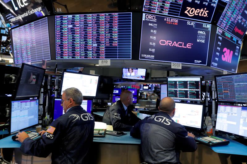 FILE PHOTO: Traders work on the trading floor at the New York Stock Exchange (NYSE) in New York City