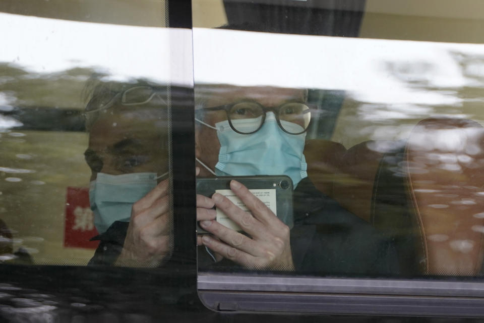 A member from the World Health Organization team of experts uses his smartphone to record after boarding a bus to leave at the end of a two weeks quarantine at a hotel in Wuhan in central China's Hubei province on Thursday, Jan. 28, 2021. (AP Photo/Ng Han Guan)