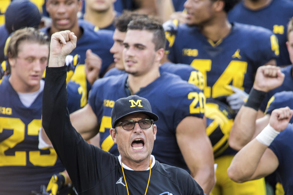 FILE - In this Aug. 26, 2018, file photo, Michigan head coach Jim Harbaugh leads his players and fans in singing "Hail to the Victors" after a practice session by the NCAA college football team at Michigan Stadium in Ann Arbor, Mich. Jim Harbaugh enters his sixth season as Michigan's coach with just two years left on his contract, adding another layer of interest in the 18th-ranked Wolverines as they kick off the season this week at No. 21 Minnesota.(AP Photo/Tony Ding, File)