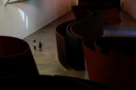 Visitors stand next to Richard Serra sculptures at the Guggenheim Museum on the day it reopens its doors following a three-month closure, amid the coronavirus disease (COVID-19) outbreak, in Bilbao