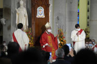 Stephen Chow, center, wearing a surgical mask to protect against the coronavirus, attends the episcopal ordination ceremony as the new Bishop of the Catholic Diocese, in Hong Kong, Saturday, Dec. 4, 2021. The new head of Hong Kong's Catholic diocese expressed hope Saturday that he could foster healing in a congregation and a city divided by the continuing fallout from massive anti-government protests in 2019. (AP Photo/Kin Cheung)