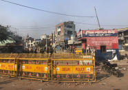 Indian security officers guard a street in a locality experiencing violence between two groups in Bhajanpura are of New Delhi, India, Tuesday, Feb. 25, 2020. At least seven people, including a police officer, were killed and dozens injured in the clashes, police said Tuesday. (AP Photo/Sheikh Saaliq)