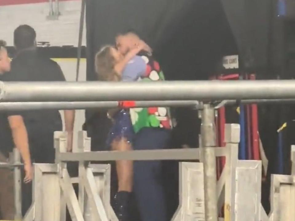 Taylor Swift and Travis Kelce kissing.