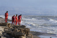 Palestinian rescue team stand on a Lebanese shore, as they wait to receive from the Syrian Red Crescent several victims of those who were on a boat carrying migrants from Lebanon that sank in Syrian waters, at Arida border crossing point between Lebanon and Syria, north Lebanon, Sept. 23, 2022. Syria's health minister says at several people have been killed from a boat that sank migrants from Lebanon off Syria's coast. The incident is the deadliest since a surging number of Lebanese, Syrians, and Palestinians have tried to flee crisis-hit Lebanon by sea to Europe. (AP Photo/Bilal Hussein)