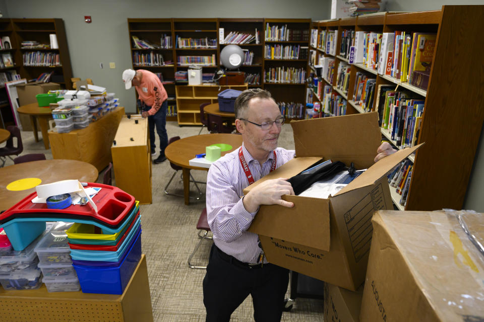The Covenant School Chaplain Matthew Sullivan looks through stored personal items as a volunteer works to get a school room ready, Friday, March 22, 2024, in Nashville, Tenn. Facing the first anniversary of a tragic shooting which left six people dead, the school, which has been meeting in a temporary location, prepares to move back into it's building. (AP Photo/John Amis)