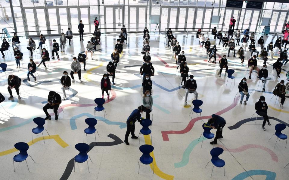 Students wait for their turn to receive their first dose of the Pfizer vaccine as Year 12 students in their final year of secondary school are inoculated ahead of their exams - DEAN LEWINS / POOL / AFP