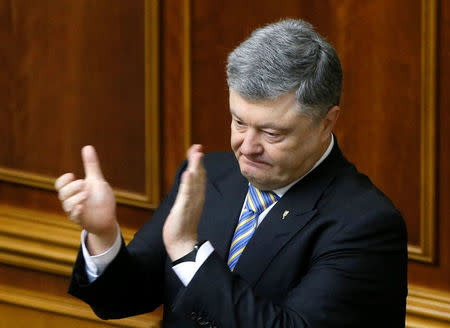 Ukrainian President Petro Poroshenko applauds after a voting on his appeal to Ecumenical Patriarch Bartholomew to create a unified Ukrainian Orthodox church free from the influence of Russia, during a parliamentary session in Kiev, Ukraine April 19, 2018. REUTERS/Valentyn Ogirenko