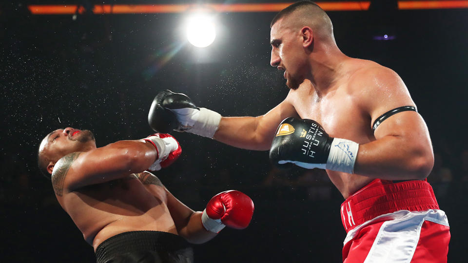 Justis Huni is pictured landing a punch on Faiga Opelu during their heavyweight bout.