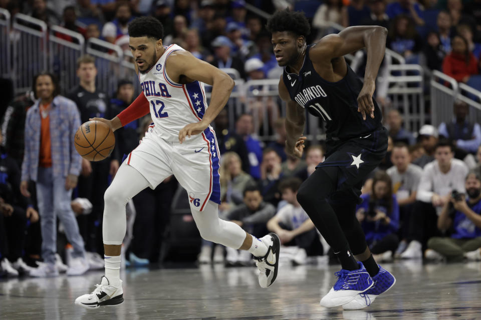 Philadelphia 76ers forward Tobias Harris (12) drives around Orlando Magic center Mo Bamba (11) during the first half of an NBA basketball game, Friday, Nov. 25, 2022, in Orlando, Fla. (AP Photo/Kevin Kolczynski)