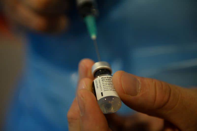 Healthcare worker holds a bottle of the Pfizer/BioNtech COVID-19 vaccine at Notre Dame home care, in Brussels