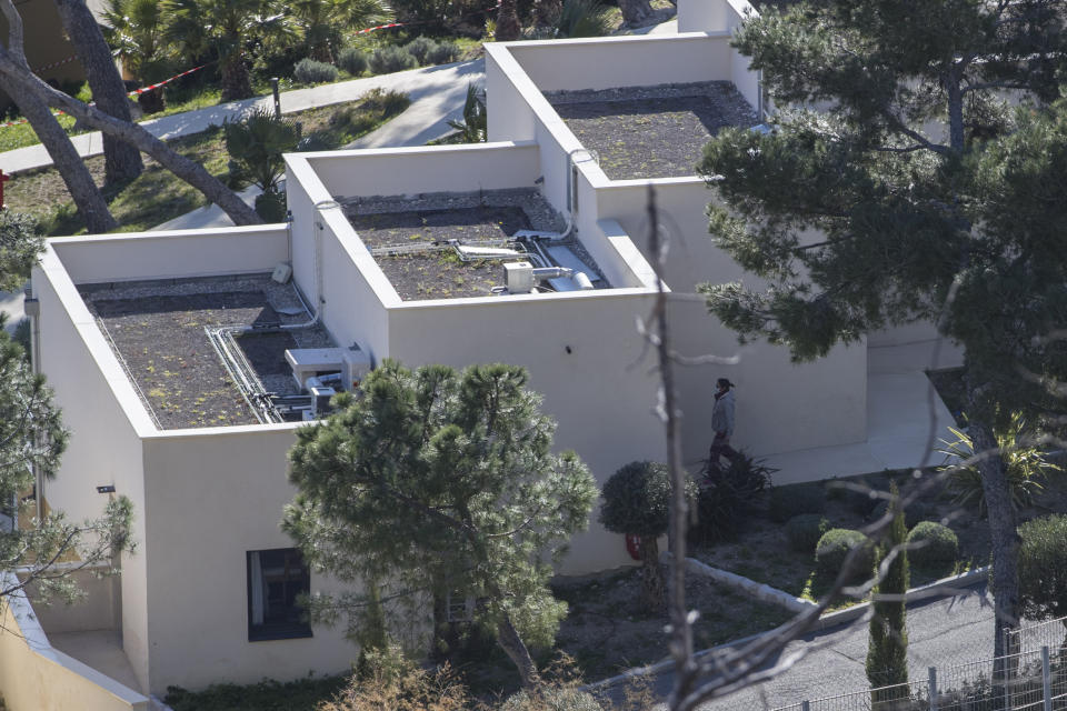 A person wearing a mask walks into a residence at a quarantined vacation center in Carry-le-Rouet, southern France, which is currently accommodating French citizens repatriated from the virus-hit city of Wuhan, Wednesday, Feb. 5, 2020. More than 20,000 people have been infected by the outbreak of a respiratory illness from the coronavirus in China. France has issued an advisory, warning against any non-essential travel to China and suggesting that French citizens who were already there return home. (AP Photo/Daniel Cole)