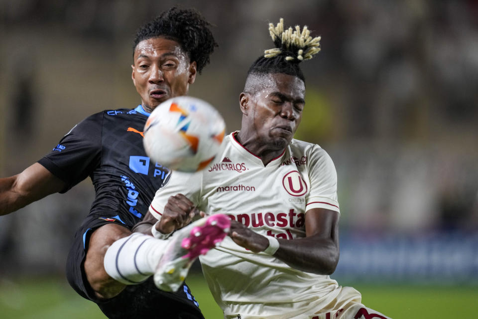 José Quintero, del Liga Deportiva Universitaria de Ecuador (izquierda), y Segundo Portocarrero, del Universitario de Perú, pelean por un balón durante un partido del Grupo D de la Copa Libertadores, en el estadio Monumental de Lima, Perú, el 2 de abril de 2024. (AP Foto/Martín Mejía)