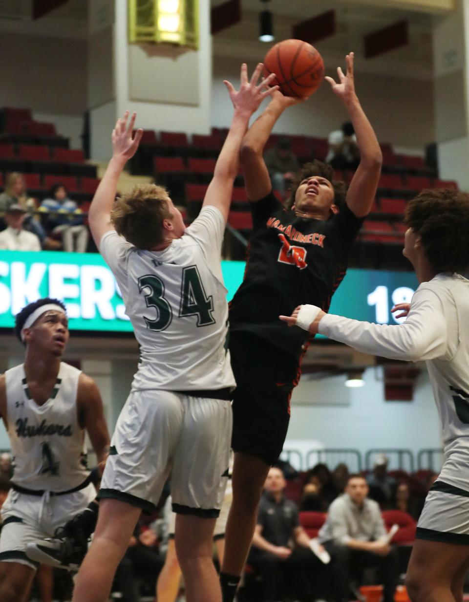 Mamaroneck's Cosmo Hardinson (20) puts up a shot in front of Yorktown's Ryan Duffy (34) during the Slam Dunk Classic at the Westchester County Center in White Plains Jan. 5, 2024.