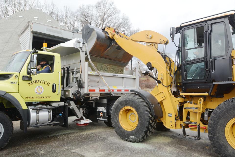 Don Sholes, crew leader at Norwich Public Works, right, puts a load of salt in a snowplow operated by Robert Patton, light equipment operator Thursday in preparation for today's snowfall.