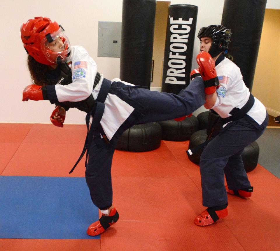 Aris Roane, 12, of Brooklyn, left, who recently won as the Tang Soo Do Grand Champion competing against adults, spars with instructor Emma Chrzanowski at Quest Martial Arts in Thompson Wednesday.