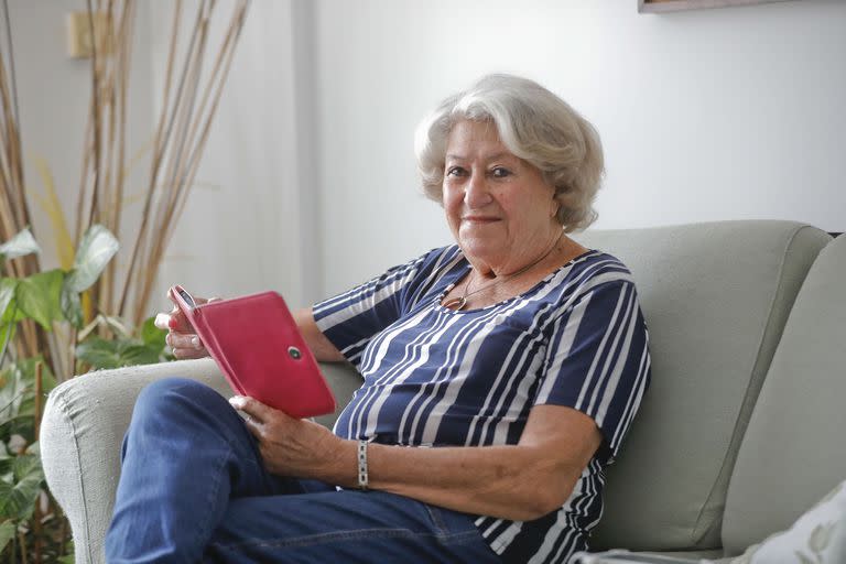 Martha Chiesa vive en colegiales, tiene 86 años y durante toda la pandemia casi no salió de su casa. En su living lee un libro en una tablet.