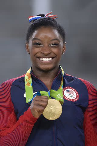 <p>Joe McNally/Sports Illustrated via Getty</p> Simone Biles earns a gold medal in the women's floor event at the 2016 Rio Olympics