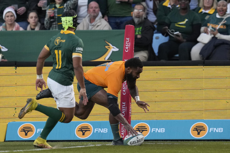 Australia's Marika Koroibete, right, scores a try as South Africa's Kurt-Lee Arendse watches on during the Rugby Championship test match between South Africa and Australia at Loftus Versfeld stadium in Pretoria, South Africa, Saturday, July 8, 2023. (AP Photo/Themba Hadebe)