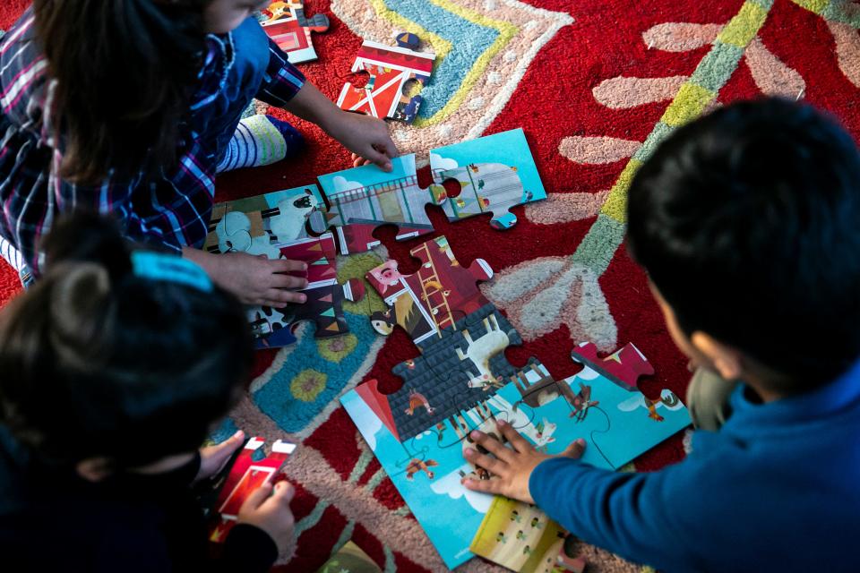 The Azizi children put together a puzzle at their home in Iowa City.