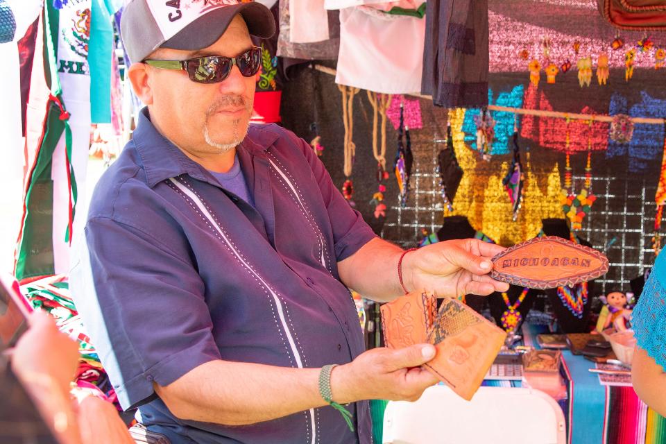 Rigoberto Murillo of Oakland shows some of his own hand made leather goods for sale at his booth at the Cinco De Mayo Festival and Parade in Stockton.